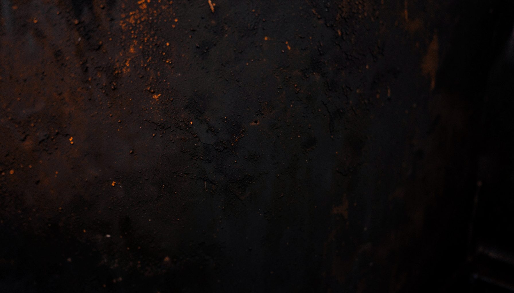 Abstract dark texture with subtle orange glow, industrial atmosphere